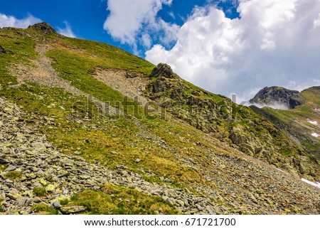 edge of steep slope on rocky hillside in cloudy weather. dramatic scenery in mountains