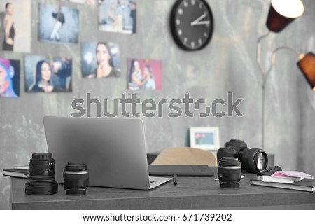 Photographer work space with laptop, graphics tablet, camera and lenses