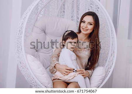 mother and daughter sitting in a chair at home