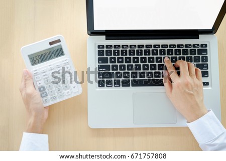 Businessman working at a computer and finds the calculator n the office workplace