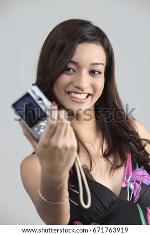 Woman holding camera and taking photo of herself	