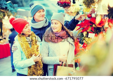 attentive parents with teenage girl at counter with Poinsettia and  floral decorations at the fair