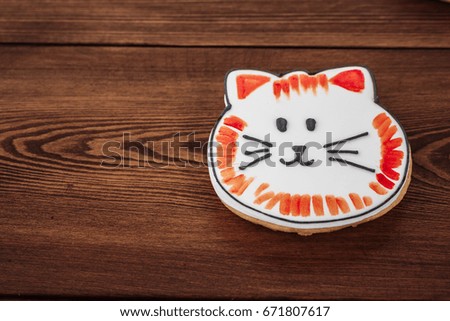 Cookies on Wooden Background. The white glaze. A picture of a cat.