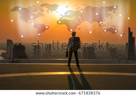 Silhouette Rear view of businessman standing with carrying the business bag and looking the vision over the cityscape background at sunset time with lens flare,Business success globalization concept