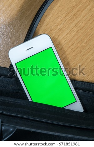 Smart phone in bag pocket with green black screen for text or picture. Concept for advertising, business.
