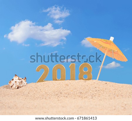 2018 year golden figures with seashell on a beach sand