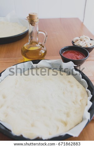 pizza bread and pizza ingredients olive oil tomato sauce and mushrooms 