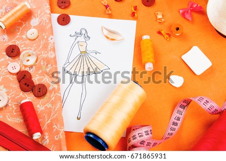 Workplace of a dressmaker: buttons, spools, measuring tape, sketch, fabric and bows