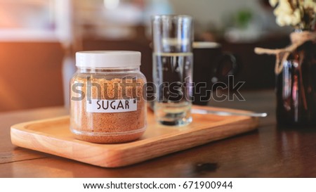 Brown sugar in bottle on wood table.