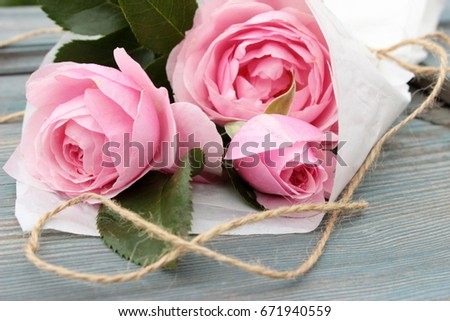 Pretty card with pure pink rose on rough blue wooden background. Shabby chi?