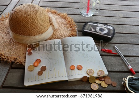 Planning travel budget. Man is counting coins. Hat, drink and calendar are on the wood table. 