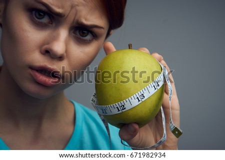 Woman with apple and measuring tape                               