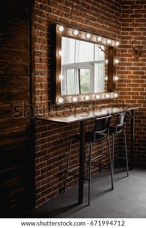 A makeup mirror with light bulbs on a brick wall background