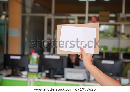 Blank white paper in the woman's hand in office.