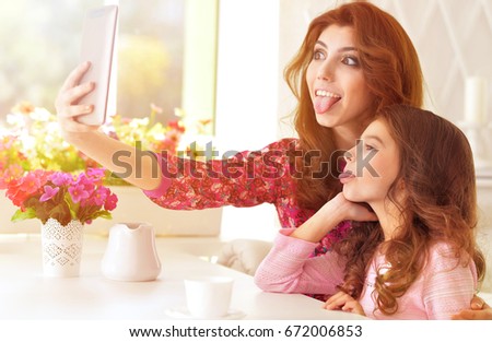 Woman and little girl using  tablet