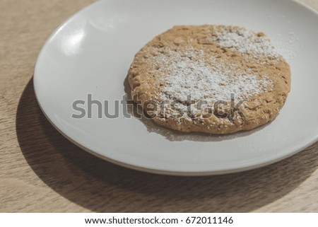 Oat meal raisin cookie on white plate.