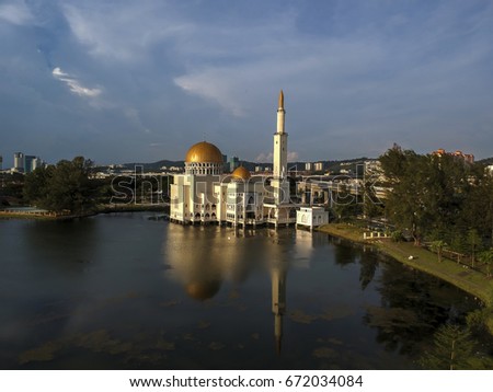 Aerial Photo - a mosque at evening. Sky is blue with bright white clouds. Soft Focus, vibrant colors.