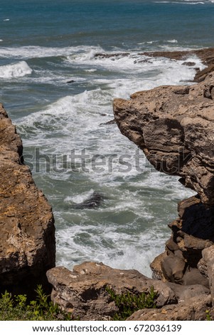 view on coast line rocks in ocean with splash waves
