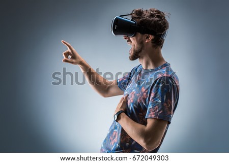 Side view of a young guy using a VR headset. Emotions