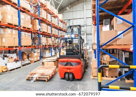 Forklift in Warehouse storage of retail merchandise shop.  Royalty-Free Stock Photo #672079597