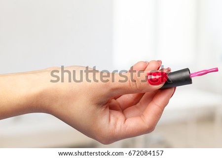 hand of young girl holding nail polish brush