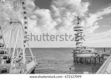 Ferris wheel on the platform on the sea beach. 