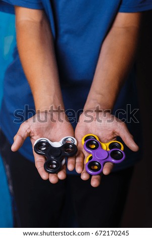 Children playing with colorful spinners. A popular toy for stress relieving for schoolchildren and adults.