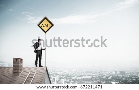 Man in suit and helmet holding yellow signboard. Mixed media