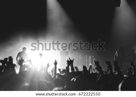 Rock band on a stage playing to the crowd with the raised up hands