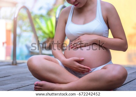Pregnant Relax, Young beautiful pregnant woman near the pool.