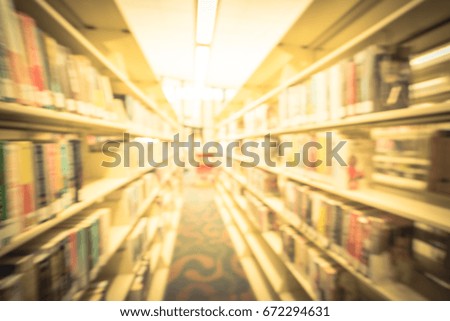 Blurred image of modern public American library interior with aisle of bookshelf full of textbook, literature, thesis, magazines. Self-study, back to school, continuing education concept. Vintage tone