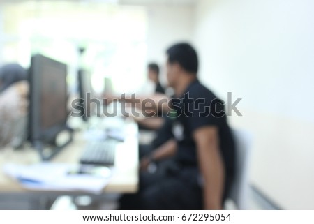 The blurred image of a man teaching a computer.
