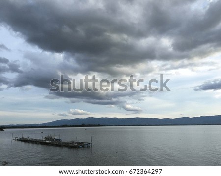 The landscape of the sky and the evening lake with cloudy rain.