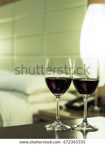 Elegant and comfortable home & hotel bedroom interior. focus on glasses of red wine.