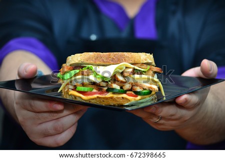 Chef Serving a Chicken Fajita Sandwich with Brown Bread Loaf 