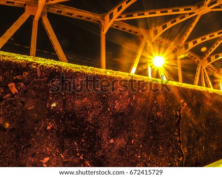 The image of the bridge over the river at night and light from the light bulb.