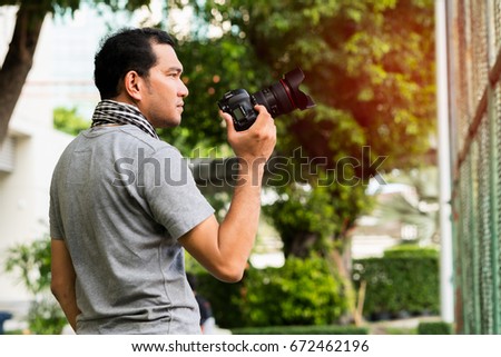 Photographer holding camera outdoor.