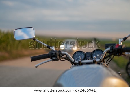 Motorbike close up with a car in the background