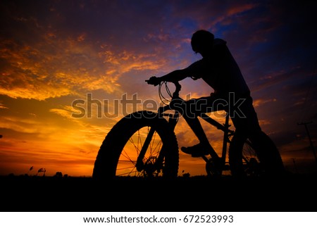 Men cyclistson the sunset background Photographed with backlight technique. light Twilight. fat bike.