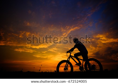 Men cyclistson the sunset background Photographed with backlight technique. light Twilight. fat bike.