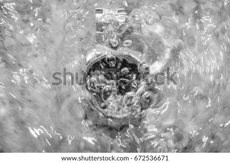 man wrist watch on the sand beach near water in black and white