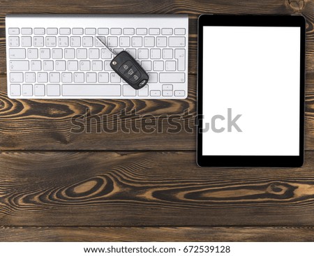 Business Workplace with wireless keyboard, tablet computer and car keys on dark wooden background. Office desk with copy space. Empty space for text