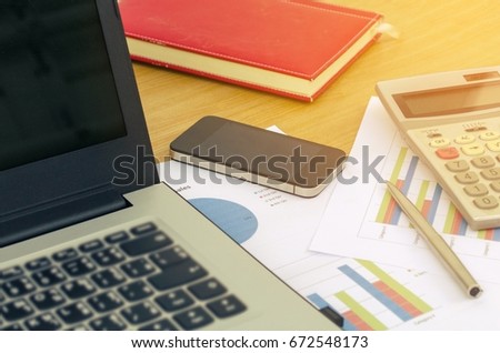 close up business accessories laptop, calculator, datasheet, pen, notebook and smartphone on desk, financial report, saving and economy business concept, sunlight effect, soft focus, selective focus Royalty-Free Stock Photo #672548173