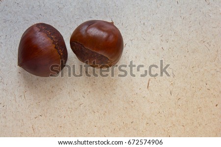 Autumn background with fresh chestnuts on kraft paper. Top view. Season picture.