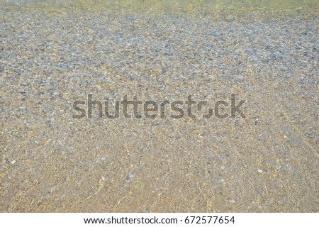 Summer background of blue wave on the sandy beach