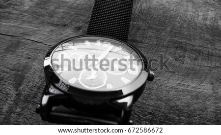 black and white stylish hand watch on dark shed wood background