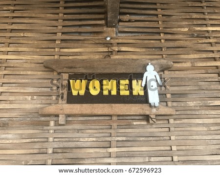 Bathroom sign for women Made of wood and with a bamboo background weave.