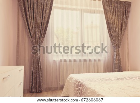 Long dark luxury curtains and tulle curtains, sheers on a window in the bedroom. Interior design concept. Vintage tinting, photo filter