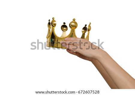 Hands holding a crown and put it on someone's head. Concept of the awards ceremony. Crown in hands isolated on white. Royalty-Free Stock Photo #672607528