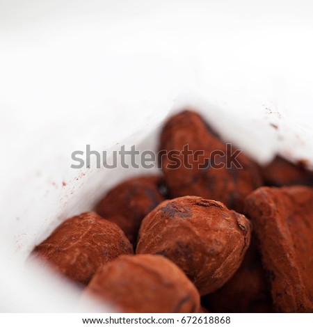 Hand made truffles in a white paper package, selective focus, 